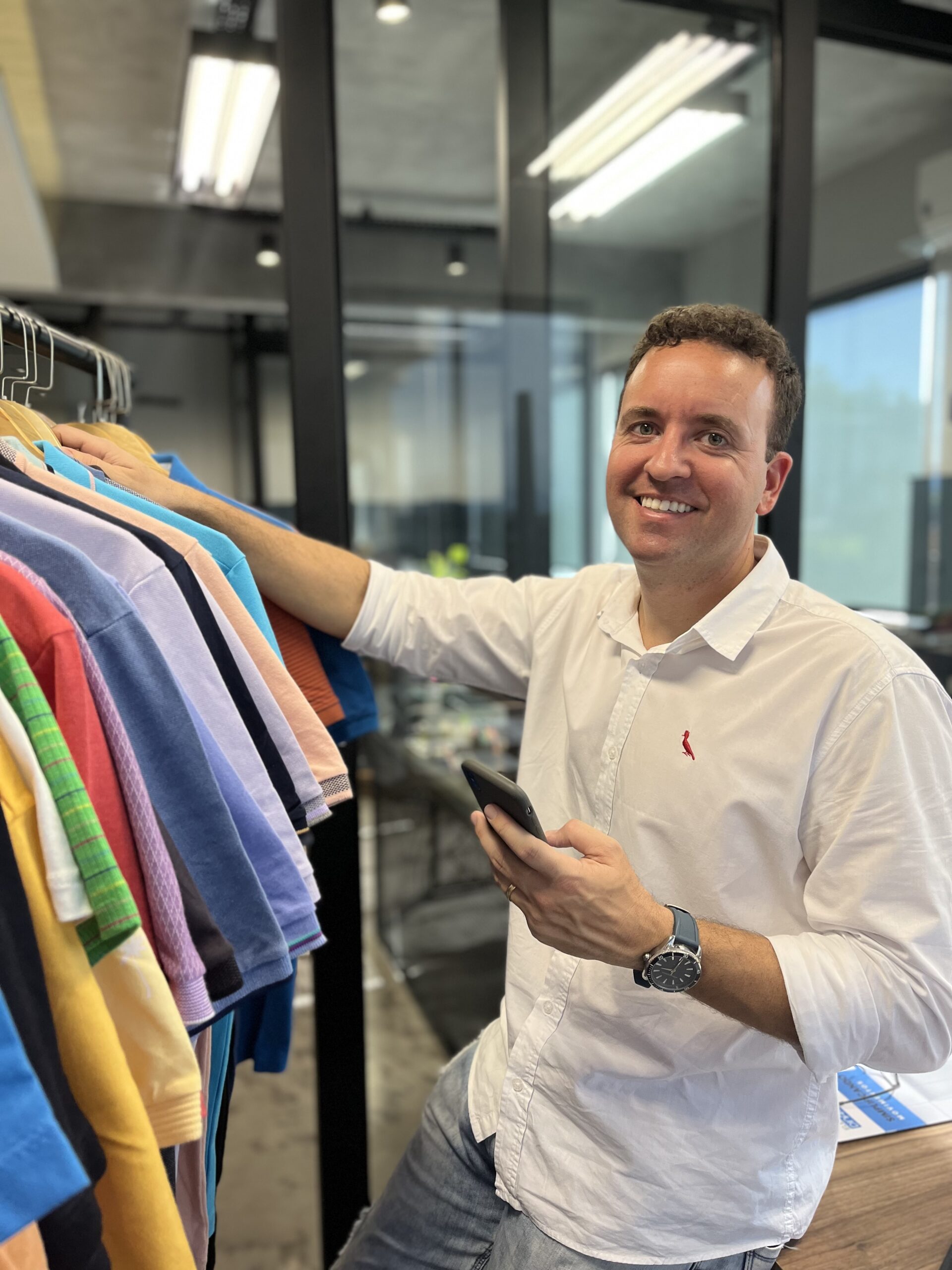 Colaborador organizando araras de roupas no showroom da Gama Têxtil